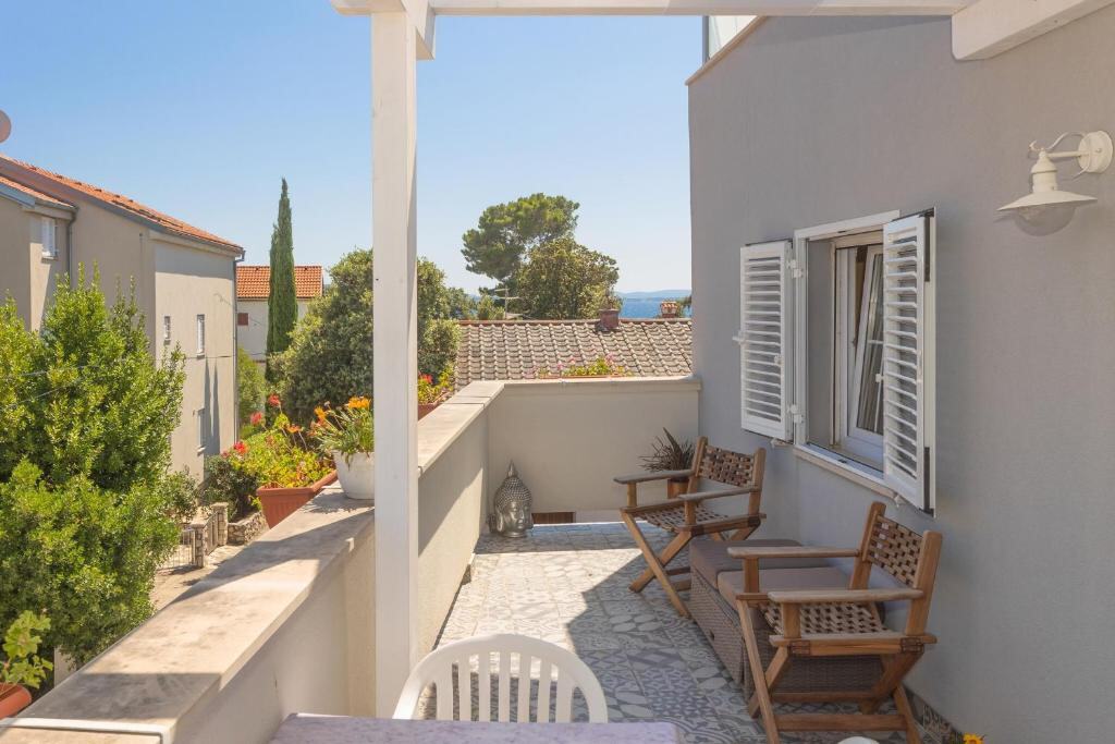 Balcony with chairs and a view over Petrčane rooftops towards the sea
